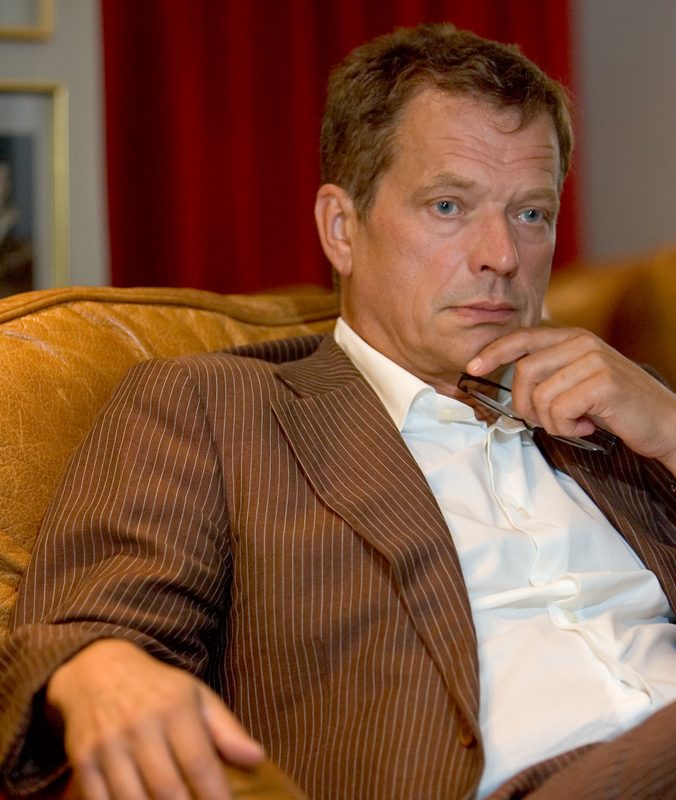 Sauli Niinistö istuu nojatuolissa ruskeassa pikkutakissa
